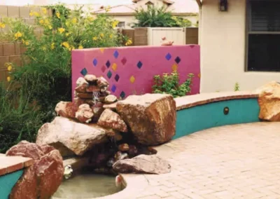 Colorful Decorative Garden Wall With Stone Fountain In Desert Landscape