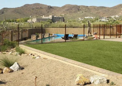 Modern Backyard Featuring Turf Area Pool And Secure Metal Fencing