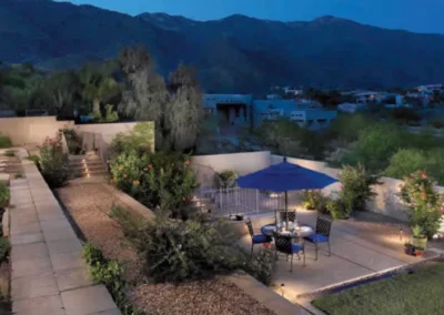 Outdoor Patio At Night With Lighting, Seating, And Garden Walls