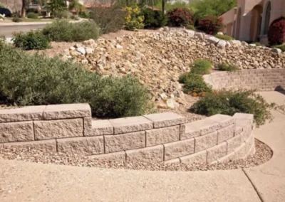 Tiered Block Retaining Wall With Desert Plants And Sloped Landscape Design