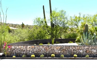 Tiered Steel Planters Filled With Desert Succulents And Cacti On Artificial Turf, Set Against A Rocky Hillside With Saguaros And Mountain Views In Tucson