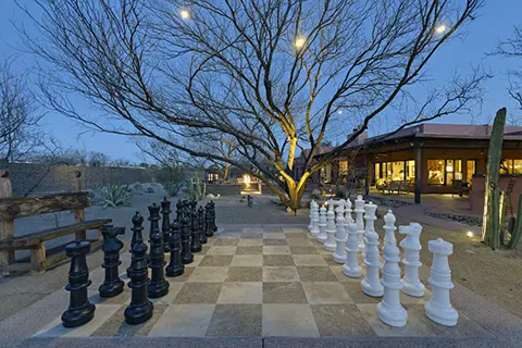 Outdoor chess set in a desert backyard patio at dusk