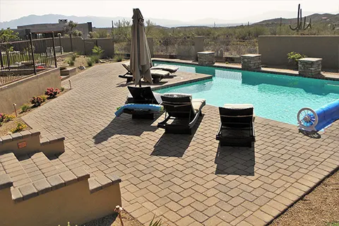 Desert backyard pool with patio and lounge chairs
