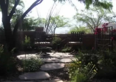 Garden landscaping with stone pathway, plants, and outdoor seating area