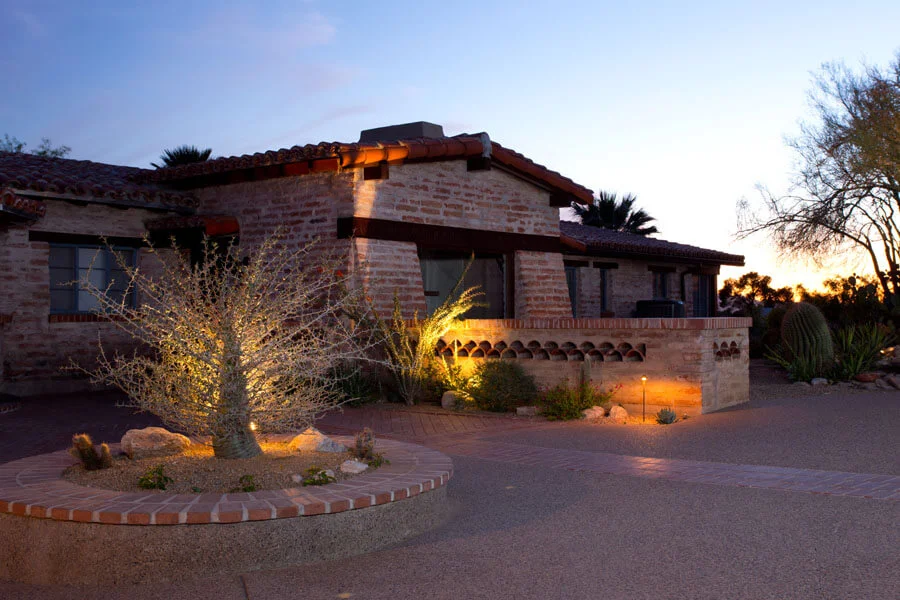 Outdoor kitchen and dining area under covered patio with mountain views at sunset