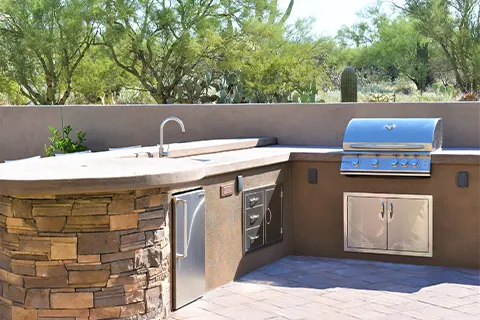 Outdoor kitchen with grill in a desert backyard