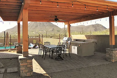 Covered outdoor patio with pergola, dining area, and kitchen