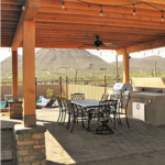 Covered outdoor patio with dining table and built-in BBQ grill in a Tucson backyard.