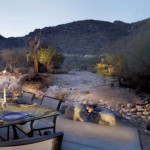 Rock fire pit with gas flame in colored concrete patio