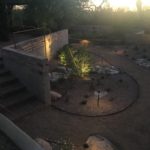 Garden space with desert plantings, berm, and custom lighting.